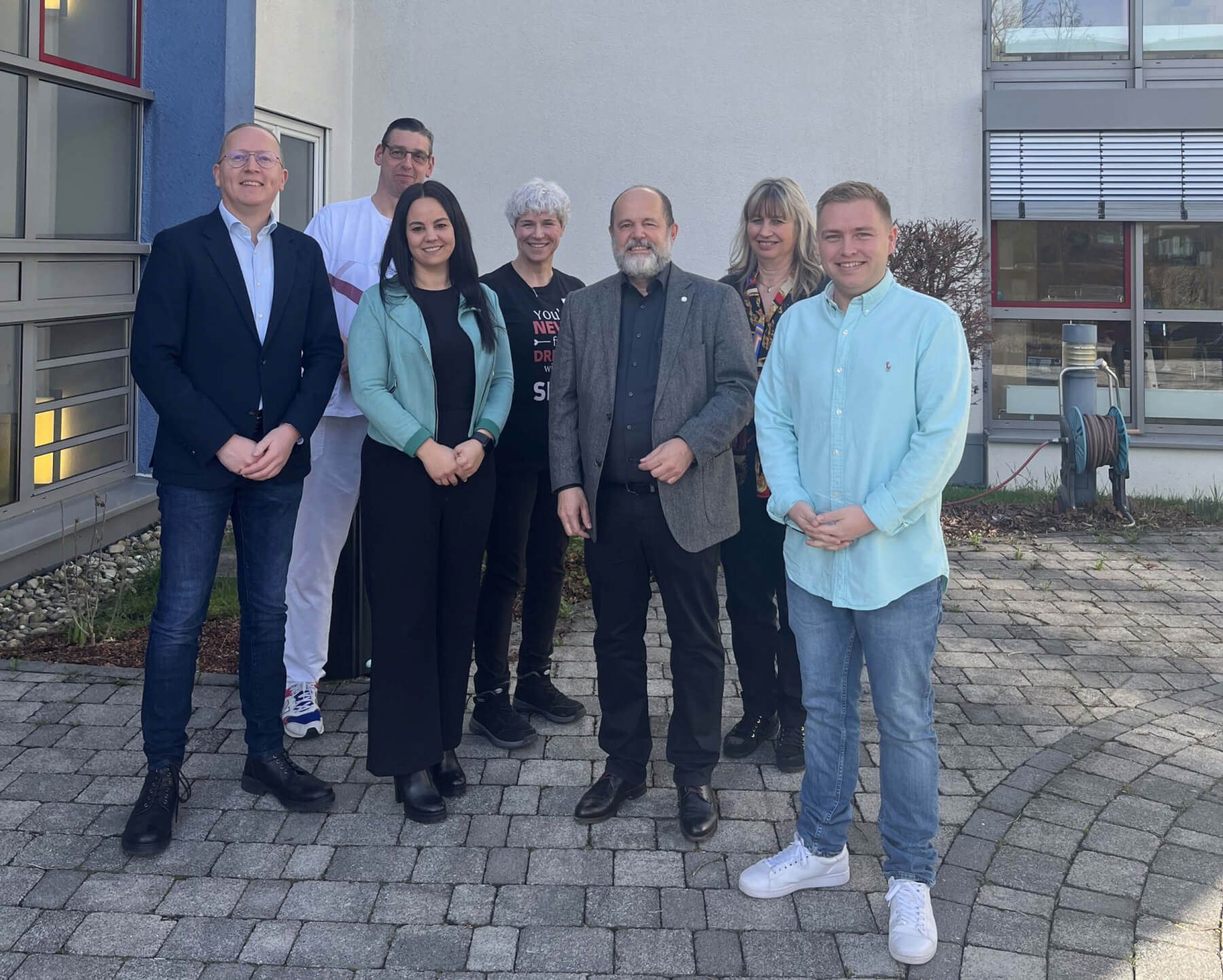 Prof. Dr. Seiter und Mitarbeiter-innen bei einem Gruppenfoto vor dem Gebäude des AWO Pflegeheims