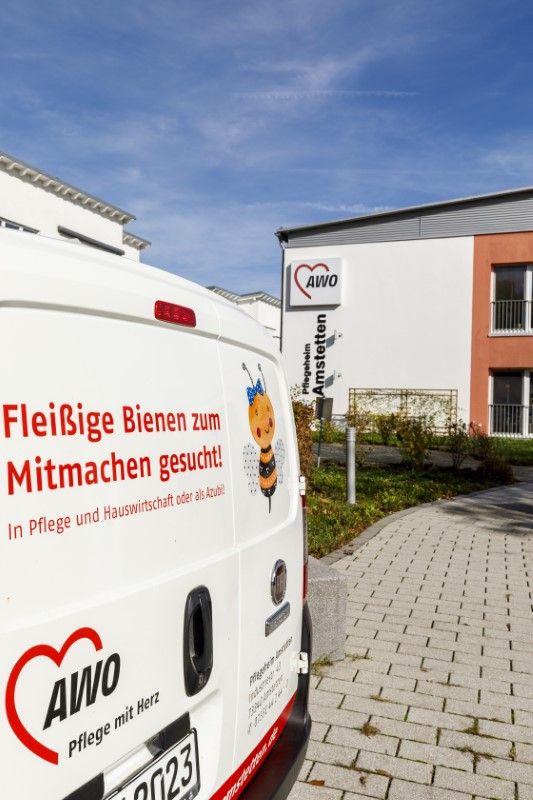 Auto mit Werbung vor der Einrichtung