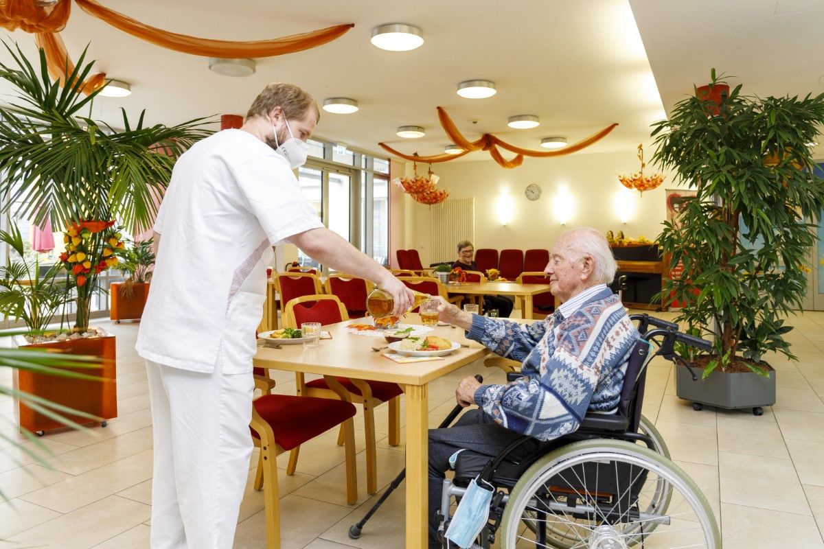 Pfleger und Bewohner im Speisesaal