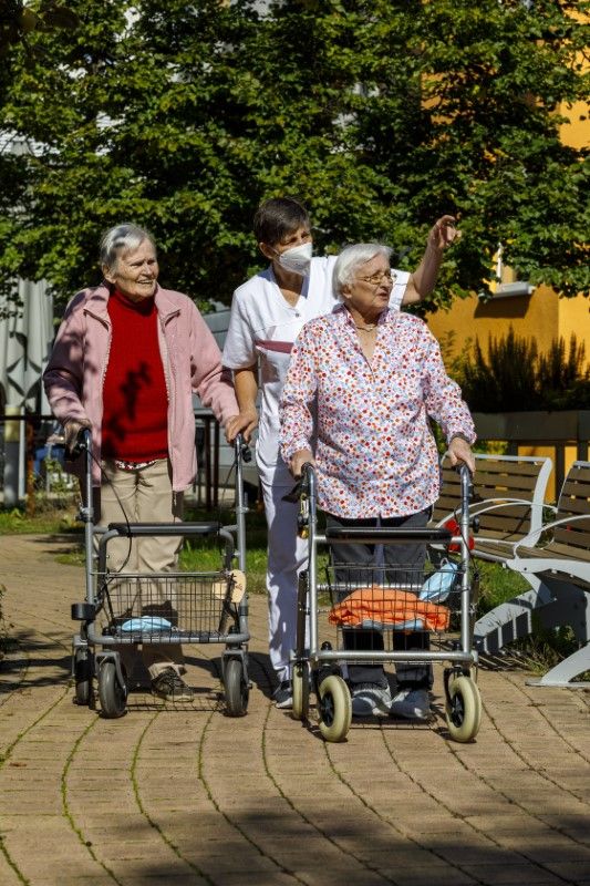 Pflegerin zeigt den Bewohnerinnen etwas