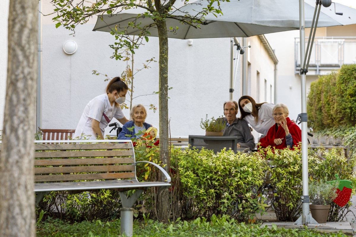 Bewohner*innen sitzen an der frischen Luft